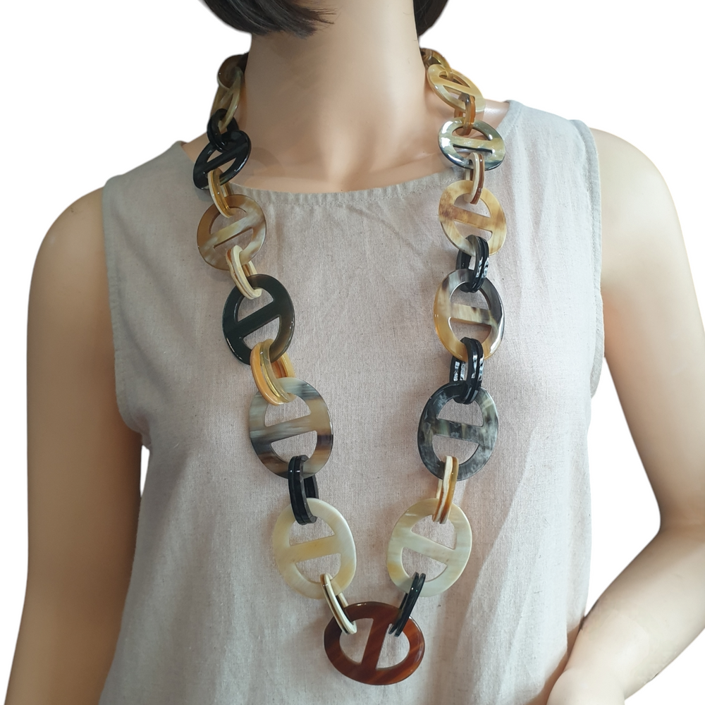 A model is wearing a statement cow horn necklace