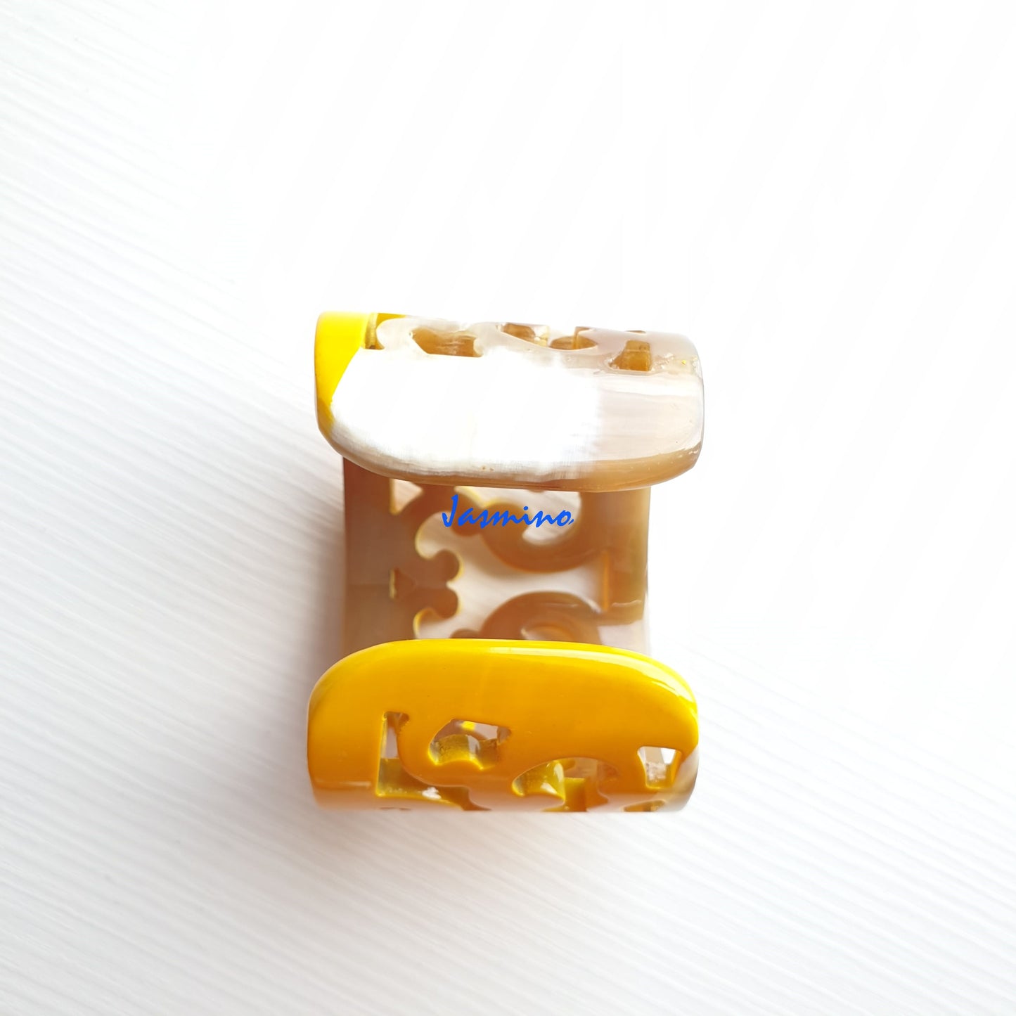 A handmade cuff bracelet features natural buffalo horn and yellow color on a white background