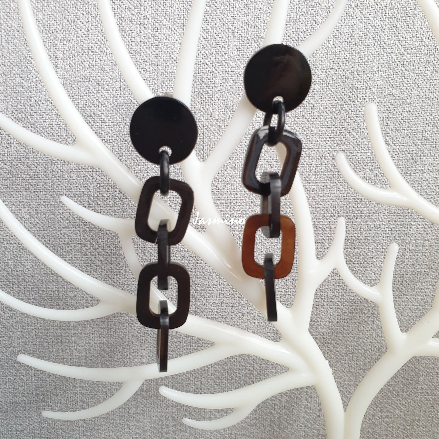 Handmade chain links earrings feature dark colours and natural buffalo horn material on white faux branches