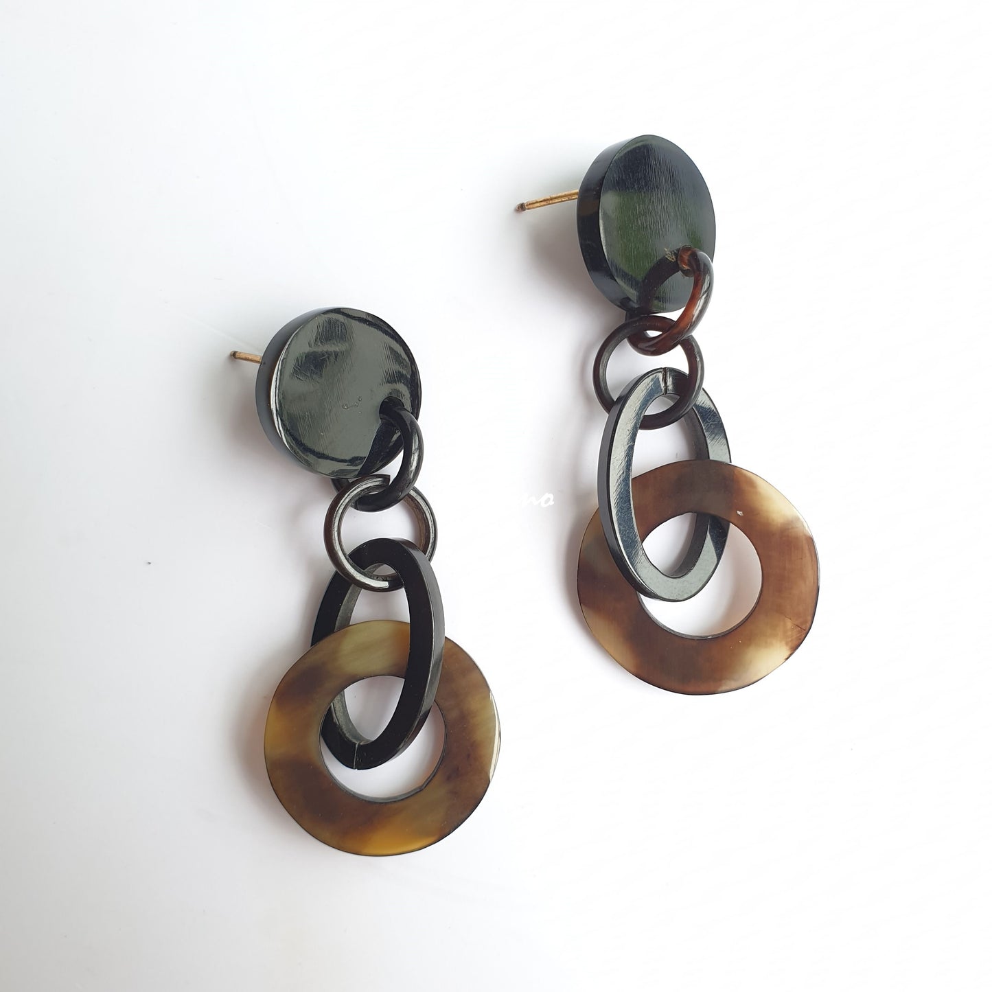 Handmade circular earrings are detailed by dark colors and natural buffalo horn that are inspired by Bohemian and Gothic style in the natural light