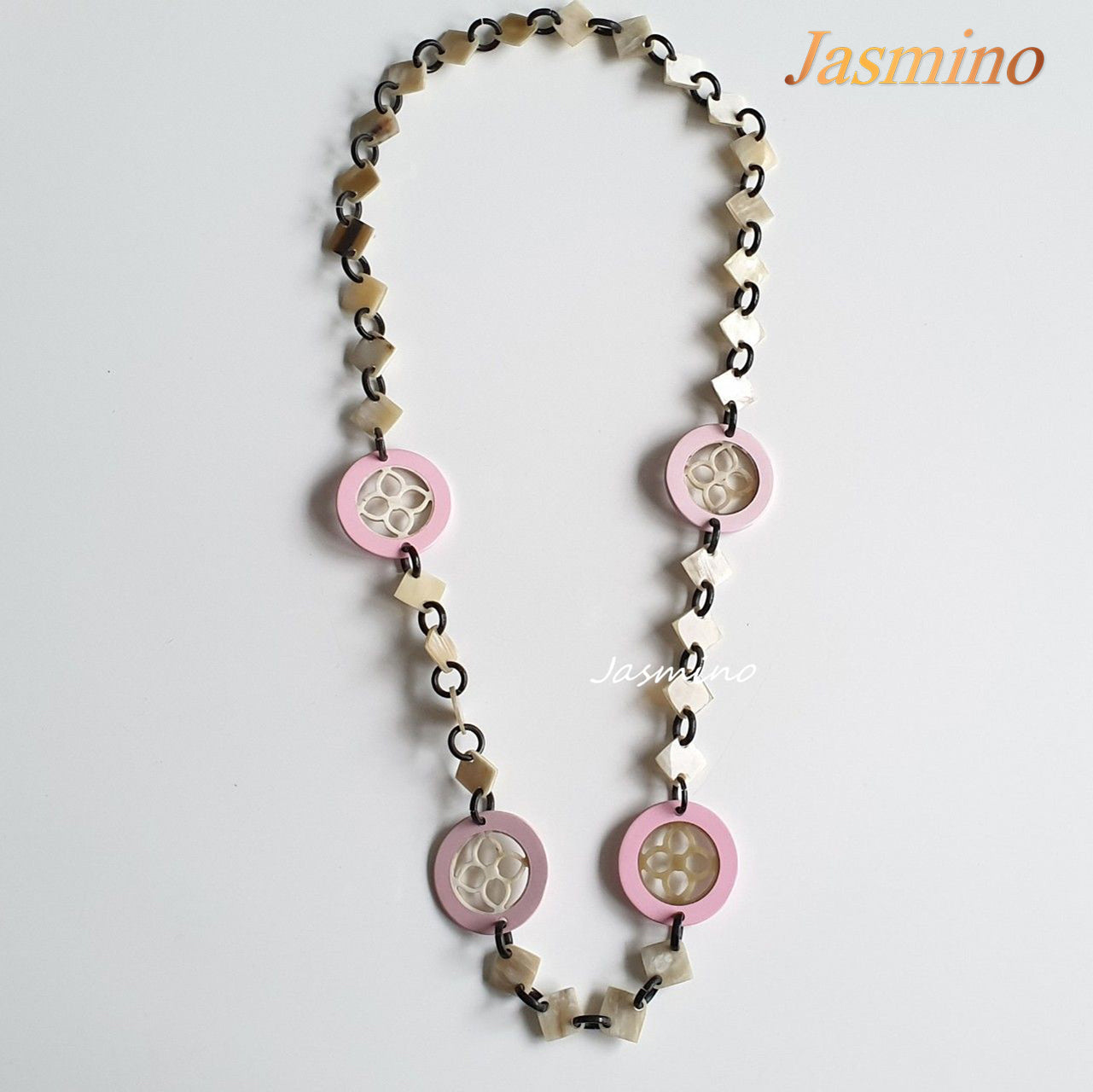 This necklace is made of natural lozenge buffalo horn pieces and four circle pink horn pieces with a unique pattern stands out on a light background, is a unique gift for friends