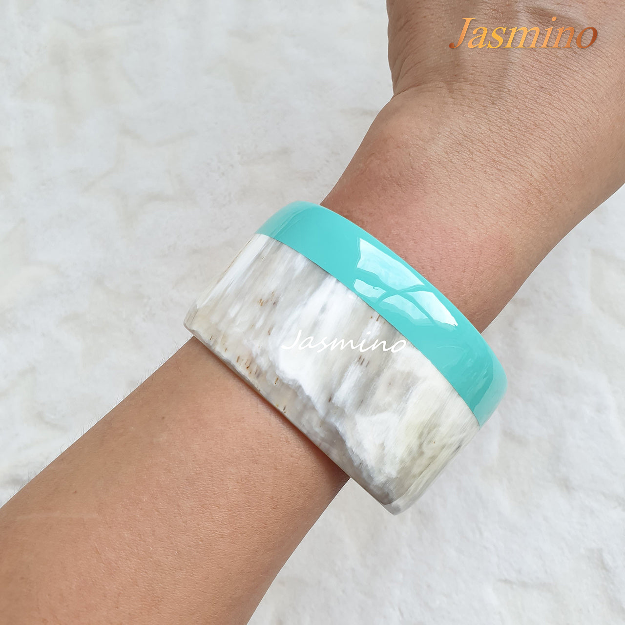 A model is wearing round turquoise lacquer buffalo horn bracelet on the light background, unique gift for her