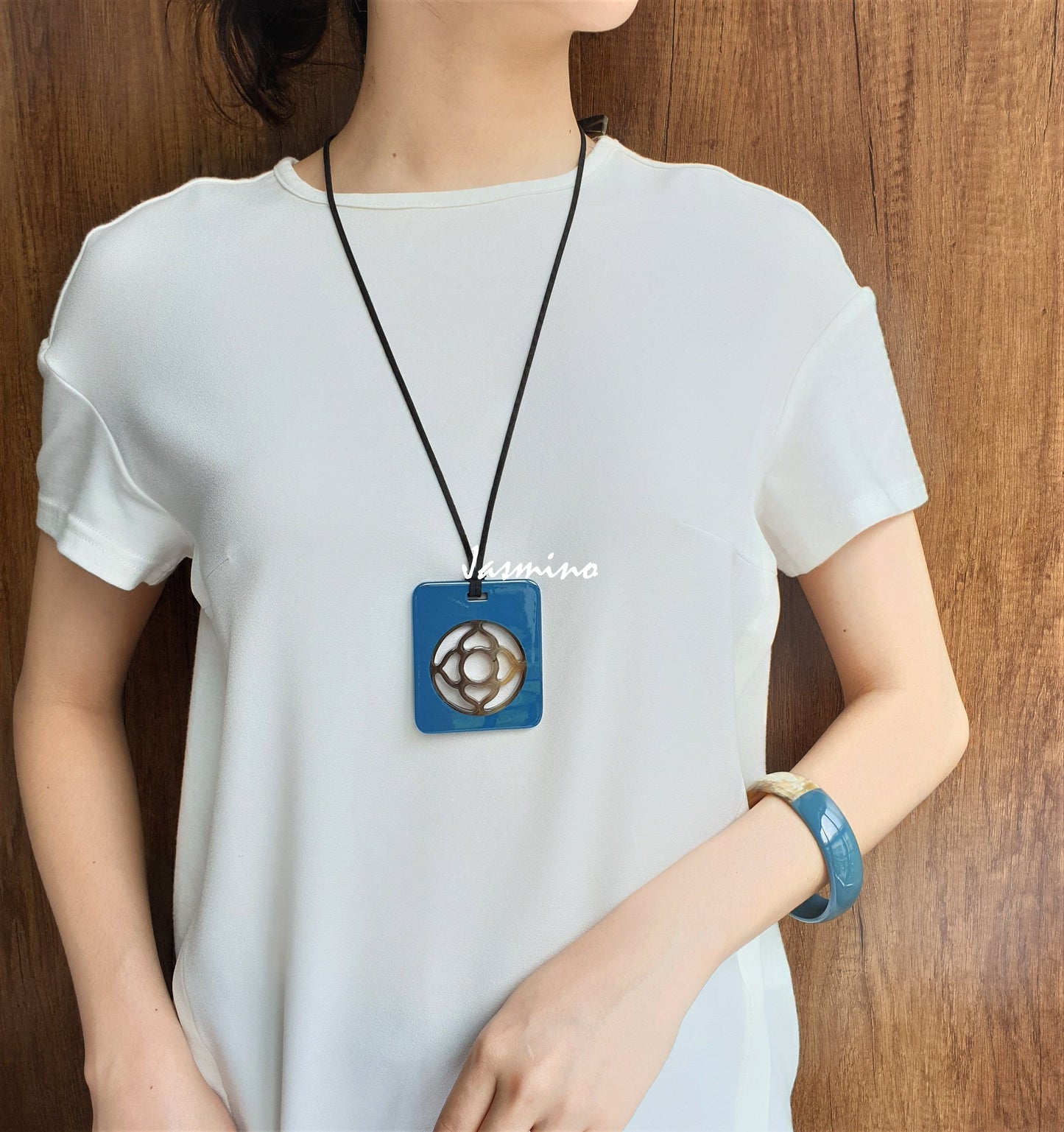 A model is wearing unique handmade Vintage turquoise rectangle pendant has a central lotus shape in natural buffalo horn for women