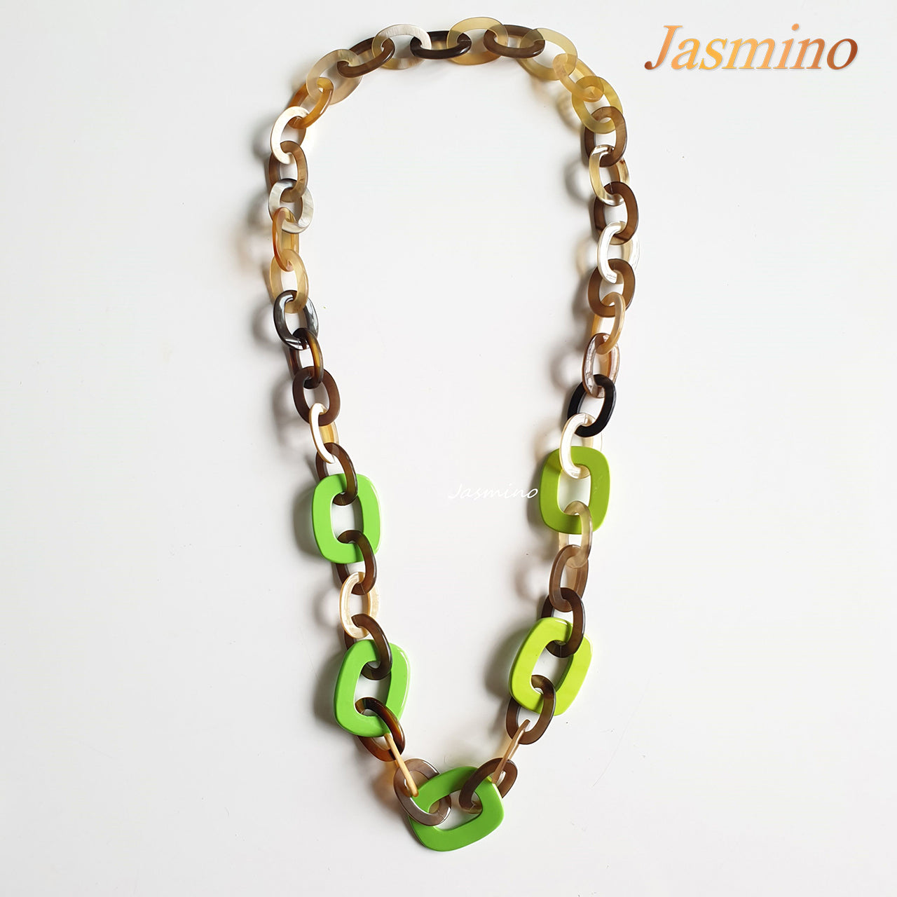 This necklace is made of elliptical buffalo horn pieces, centered by five lime zest horn pieces that stand out on a light background