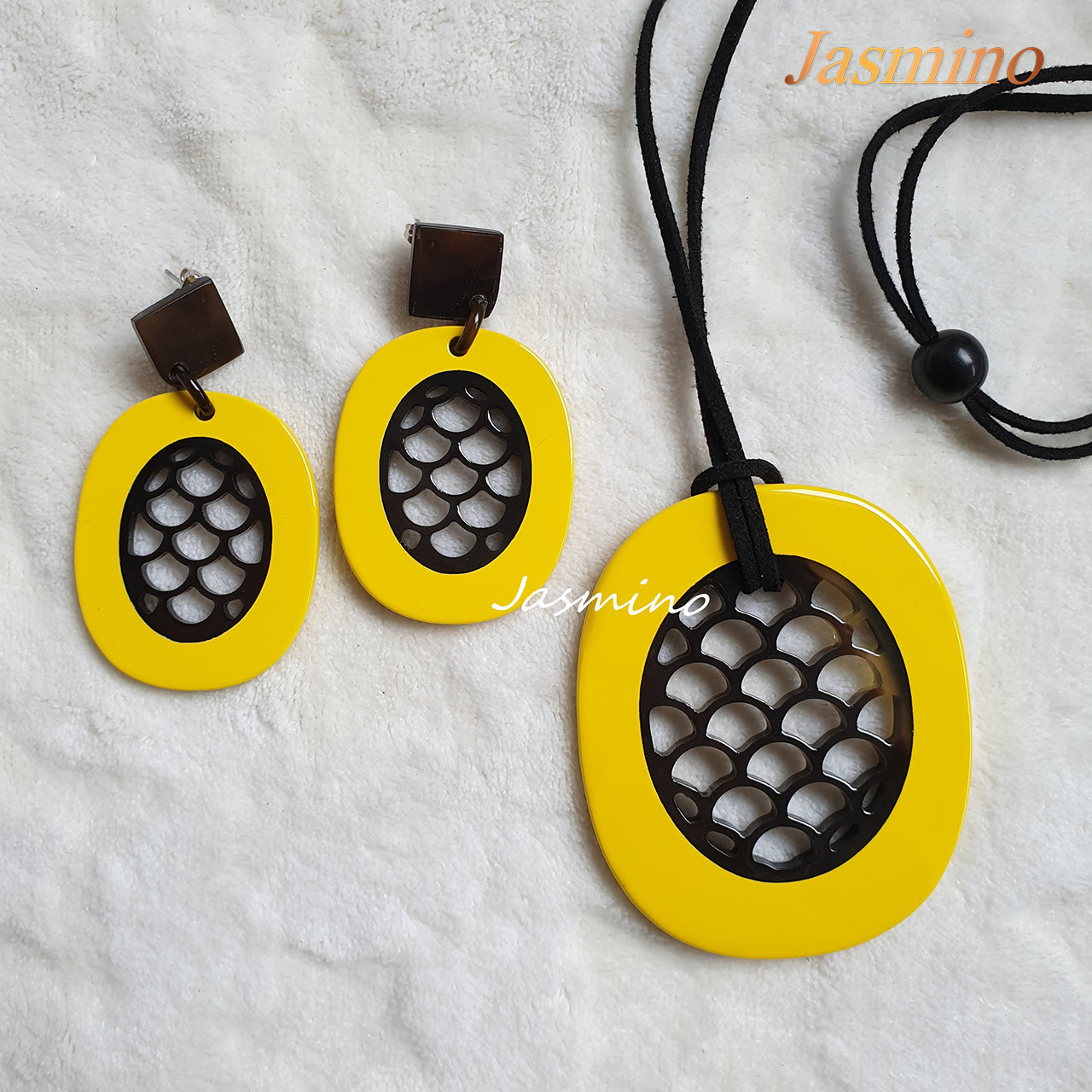 A set of unique handmade yellow oval drop earrings and pendant in natural buffalo horn