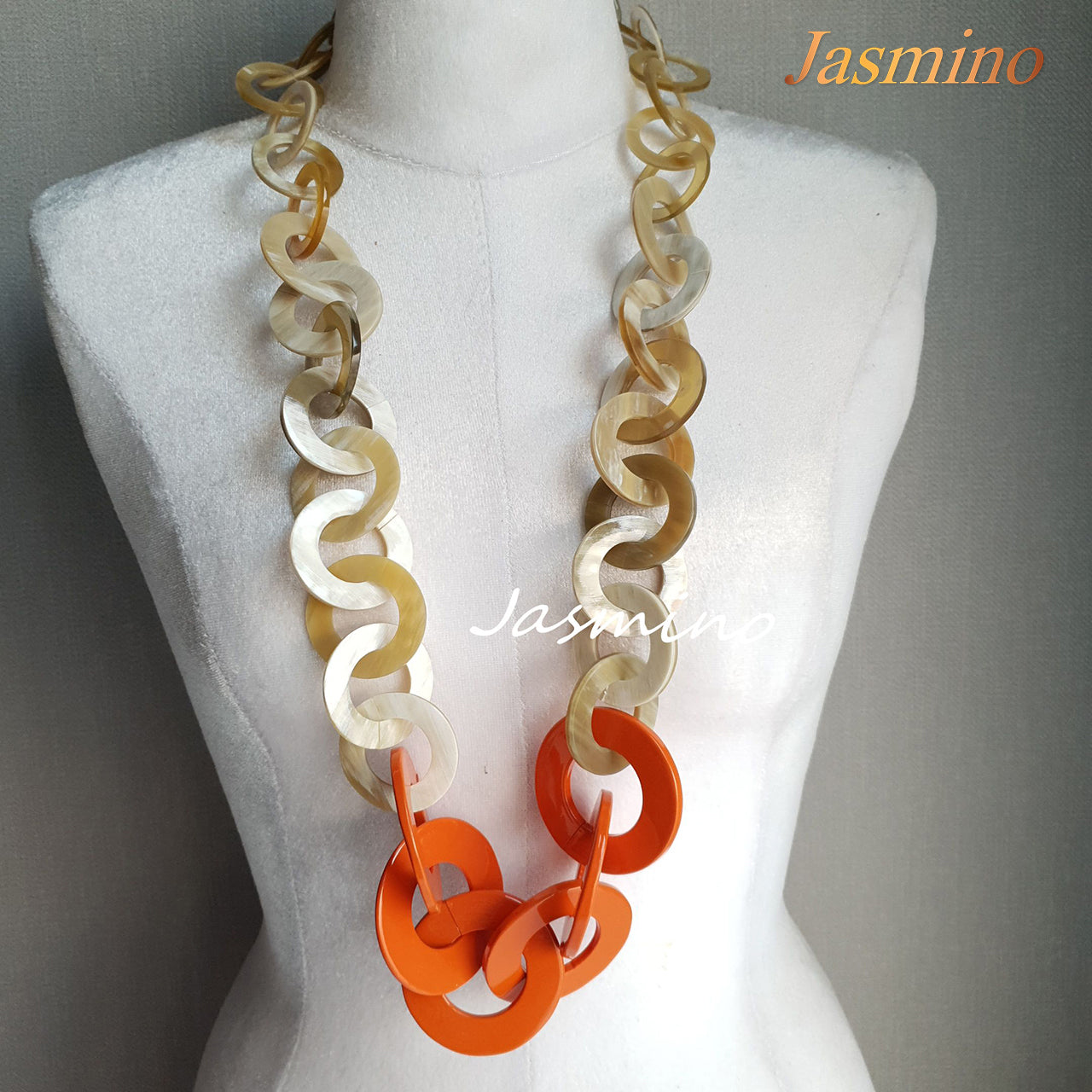 Orange peel necklace made from a series of lacquered circular horn pieces on a light background, an impressive gift for her