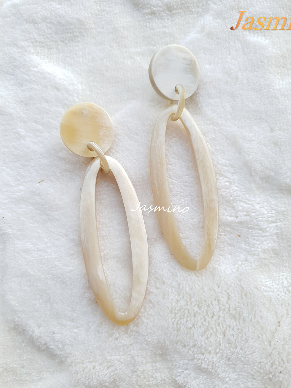 Jasmino Minimalist handmade long thin teardrop earrings for women feature a white color in the natural light