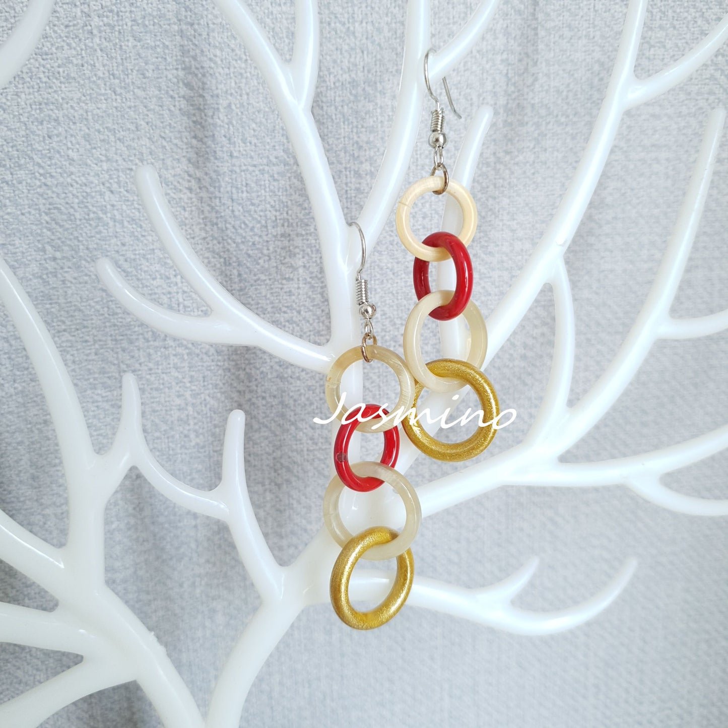 Handmade circle link dangle earrings feature red, yellow, and white color in the natural light 