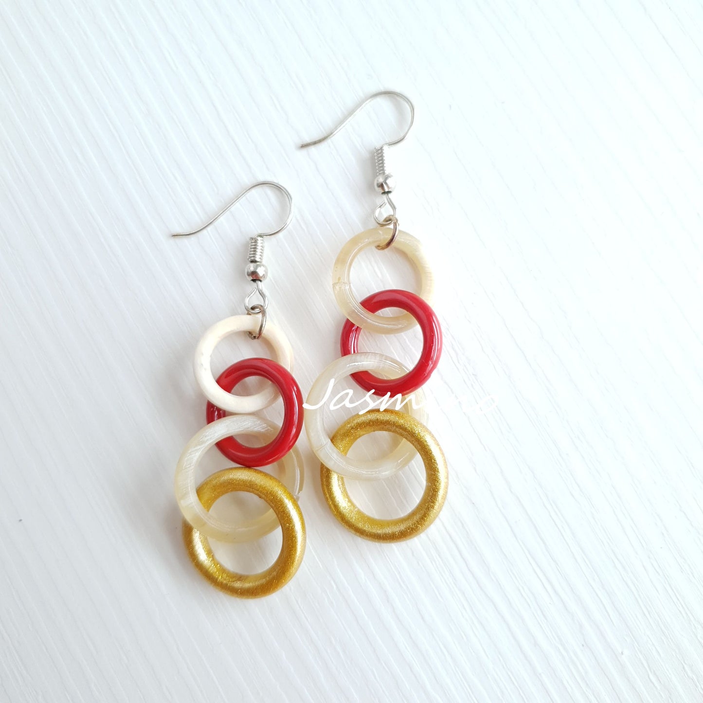 Handmade circle link dangle earrings feature red, yellow, and white color in the natural light 