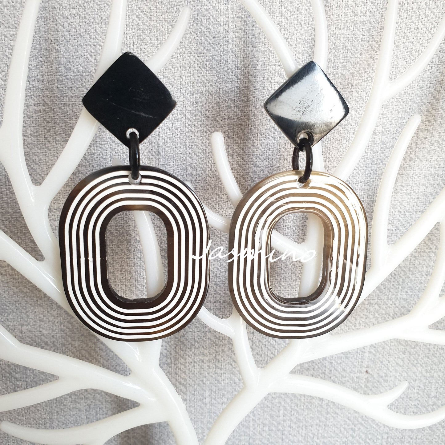 Unique spiral oval drop earrings feature brown and white color in the natural light