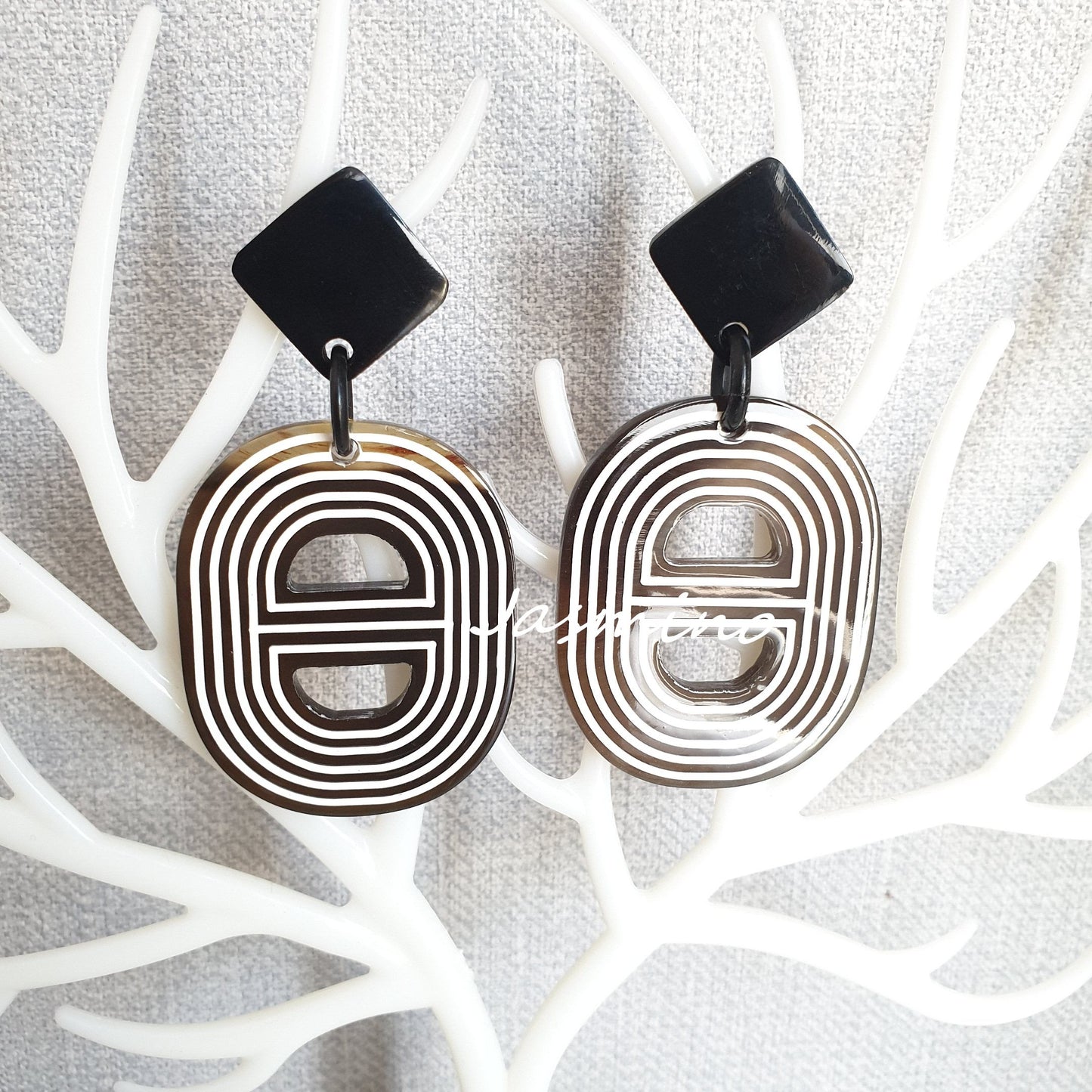 Handmade spiral double D-shaped oval earrings feature brown and white in the natural light