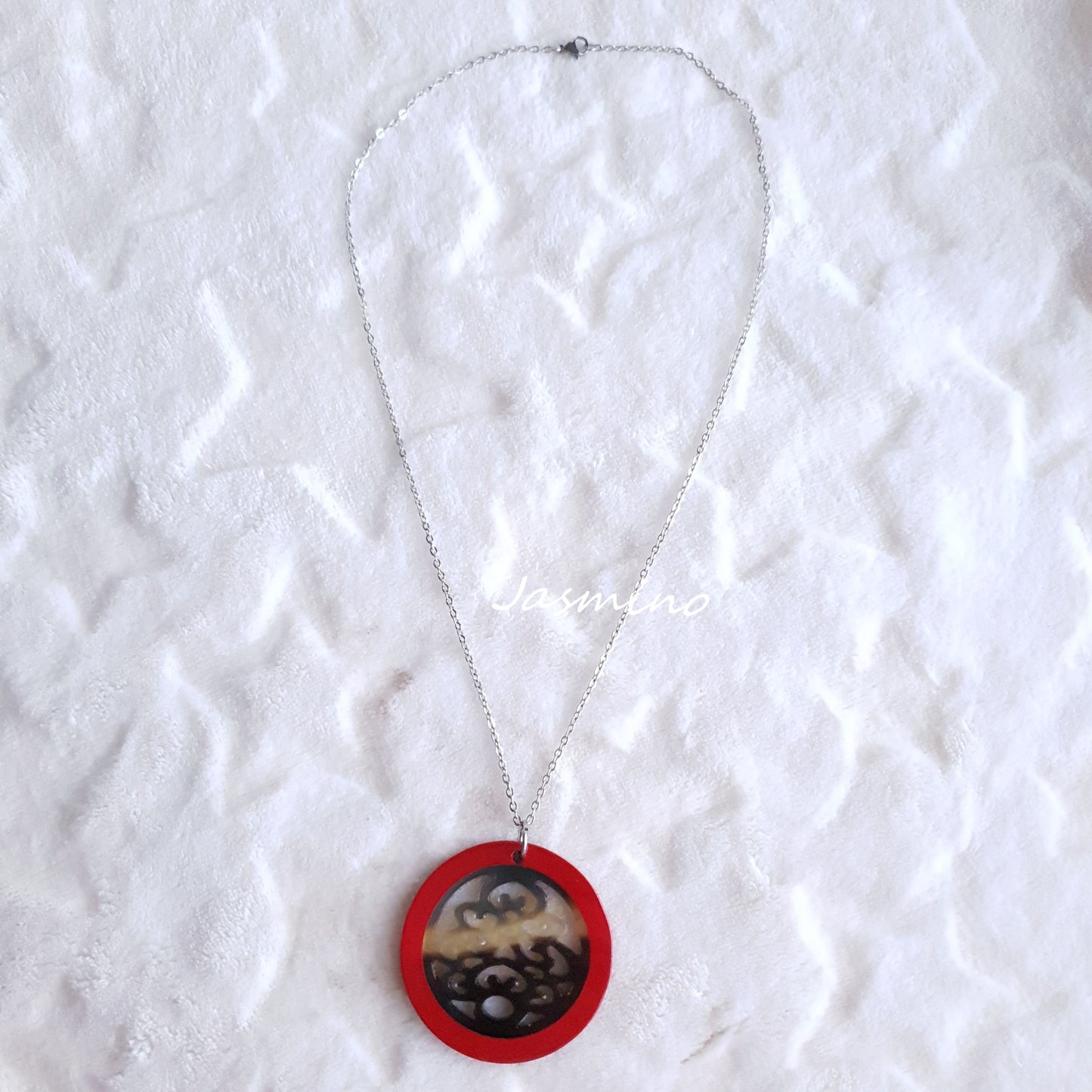 necklace has a circle pendant with scarlet outline, inside with unique pattern made from natural buffalo horn on the light background, impressive Christmas gift for her