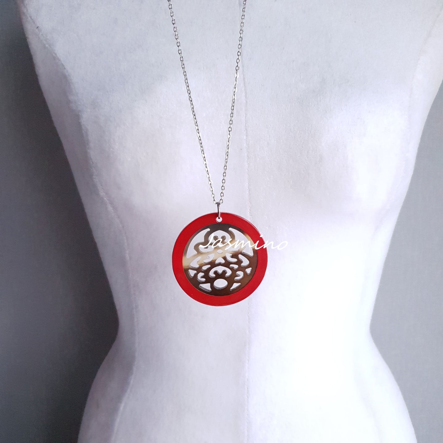 necklace has a circle pendant with scarlet outline, inside with unique pattern made from natural buffalo horn on the light background, impressive Christmas gift for her