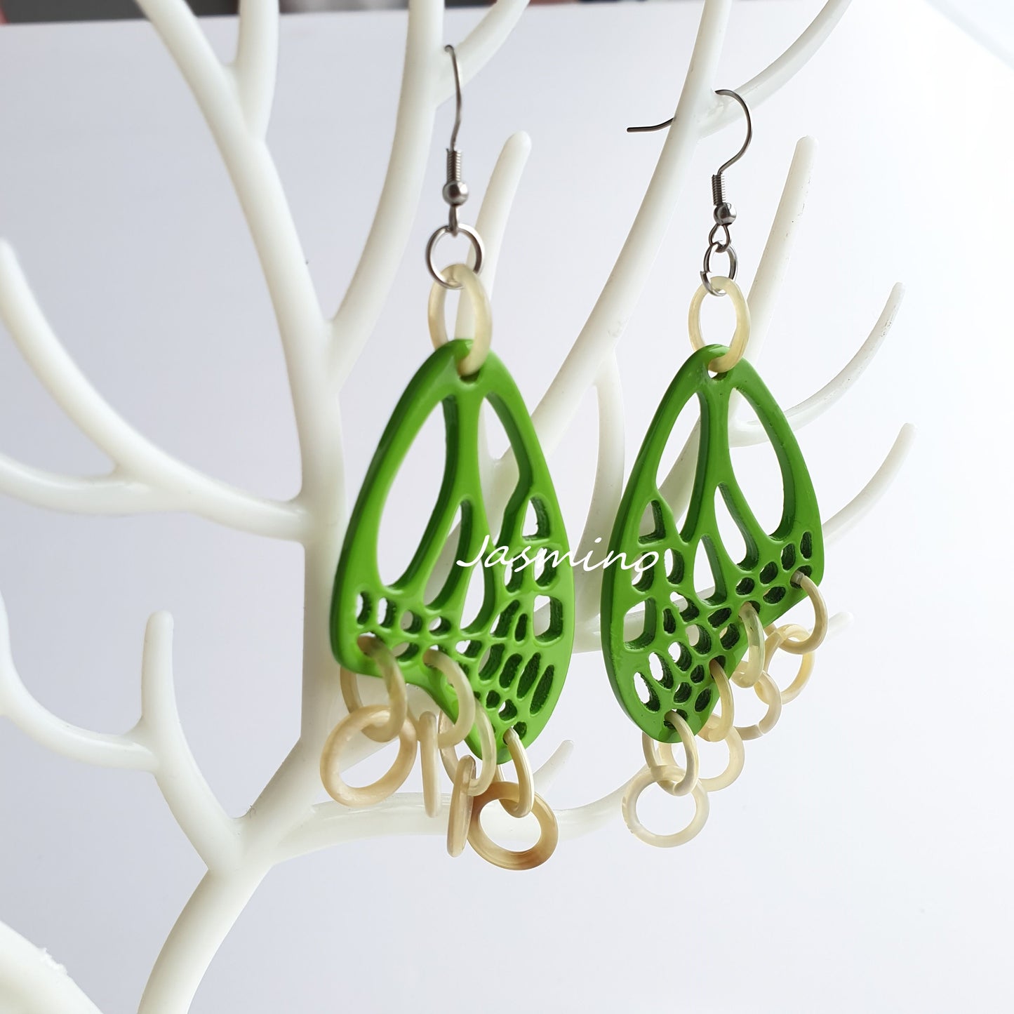 Handmade butterfly wing dangle earrings feature bright green in the natural light