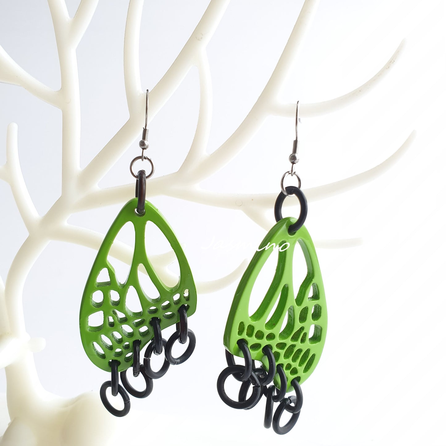 Handmade butterfly wing dangle earrings feature bright green and black in the natural light