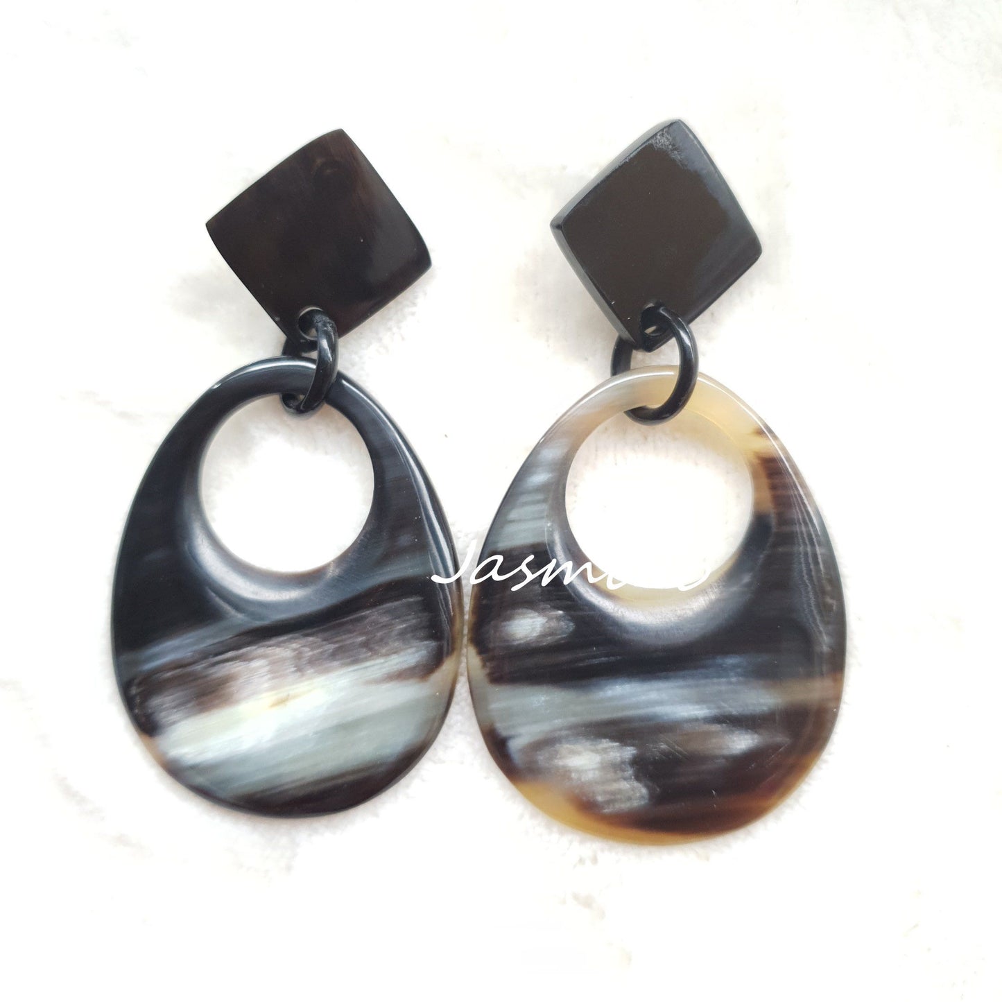 Handmade teardrop earrings feature ombre color with natural buffalo horn in the natural light