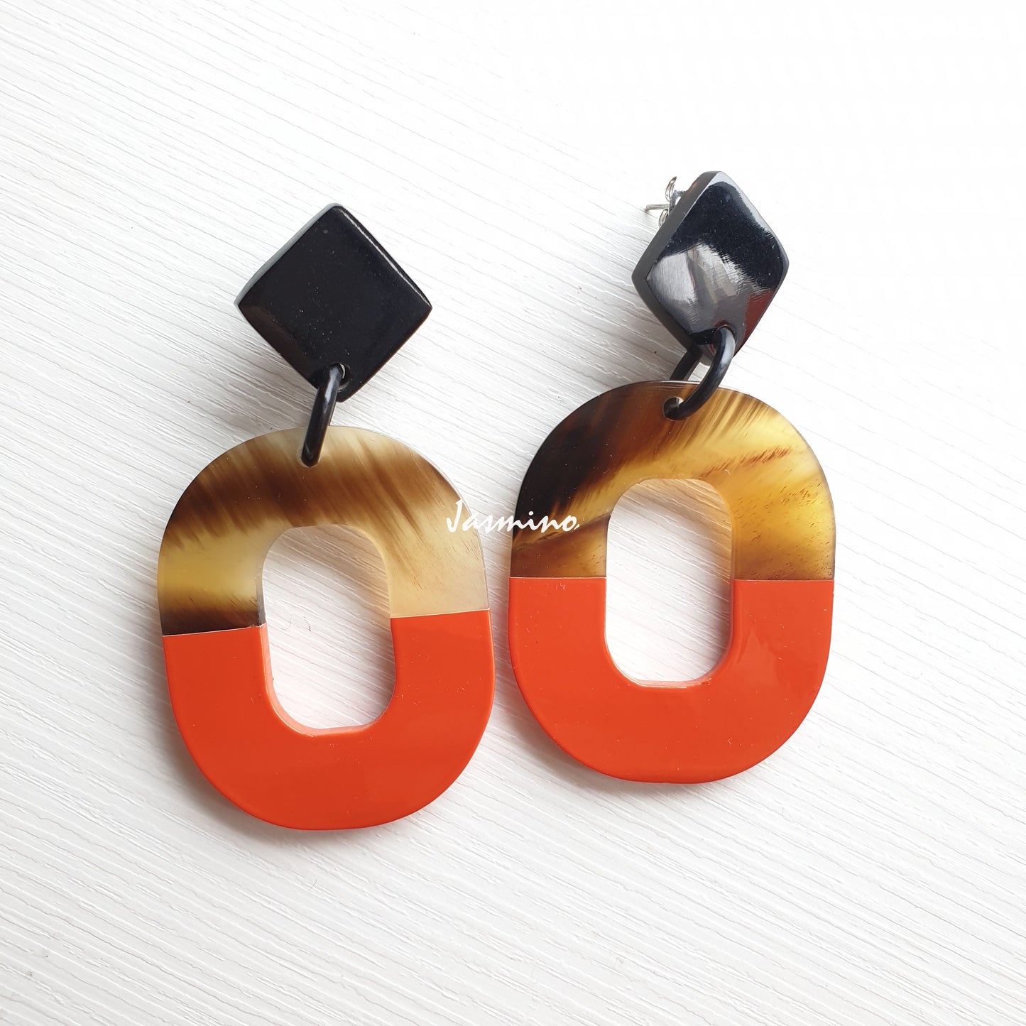 Handmade oval earrings feature burnt orange made by natural buffalo horn for women  on a white background