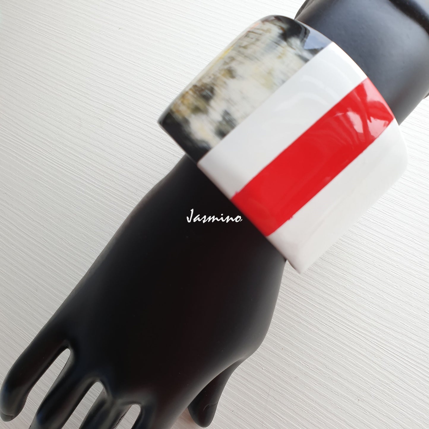 natural buffalo horn bracelet with red stripe on brilliant white painted background, an impressive gift for your friend