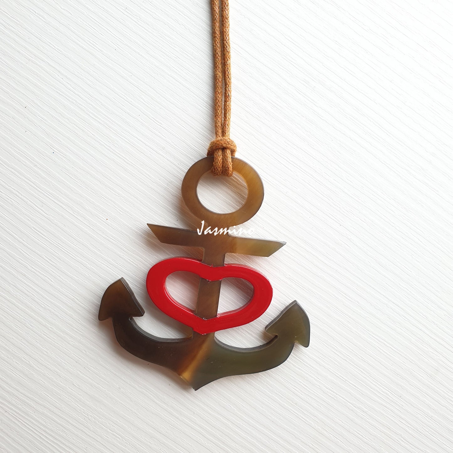 anchor shaped scarlet lacquer buffalo horn pendant on the light background for women