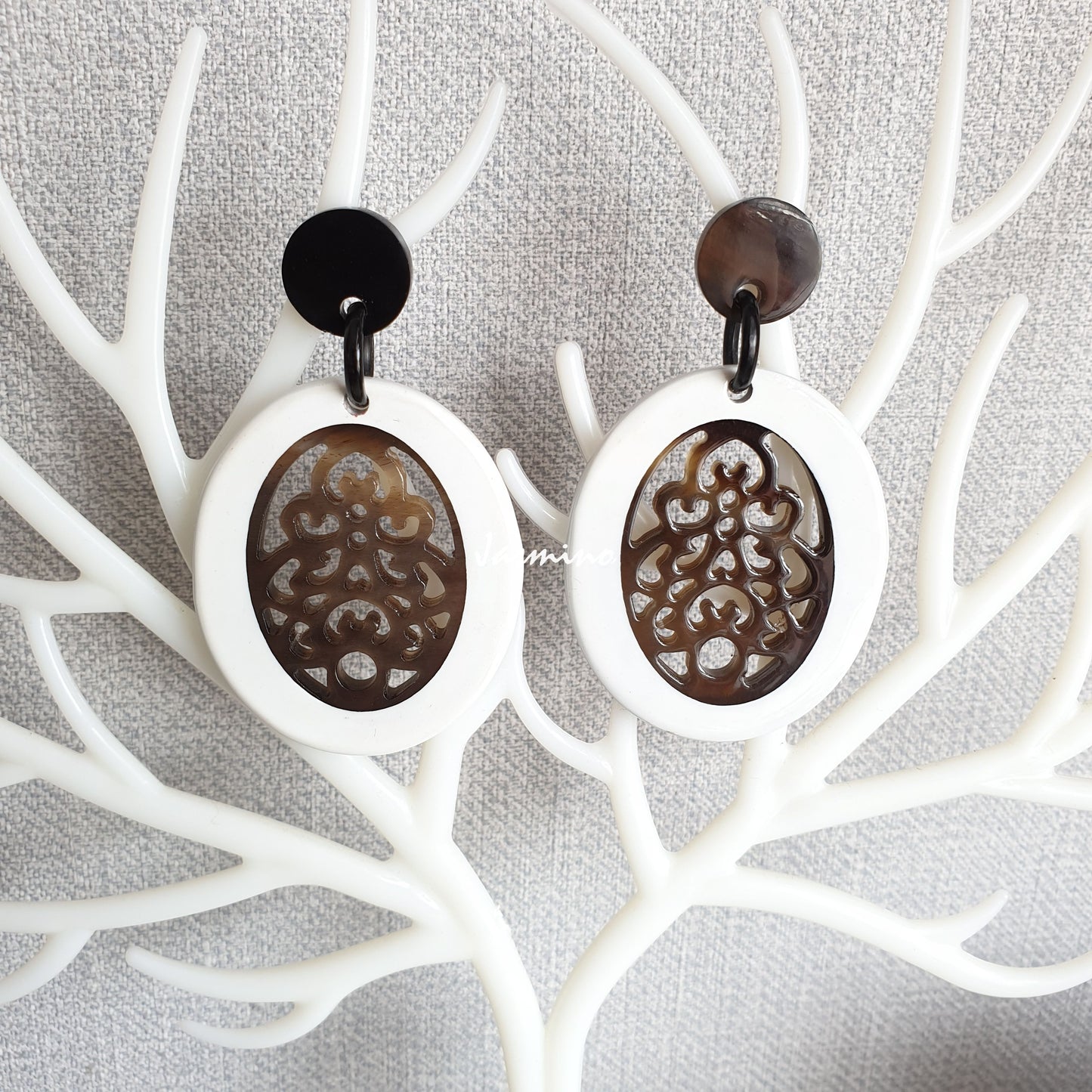 Handmade chunky large oval earrings feature brown and white in the natural light