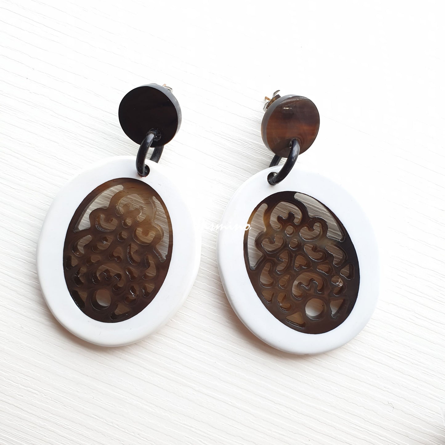 Handmade chunky large oval earrings feature brown and white in the natural light