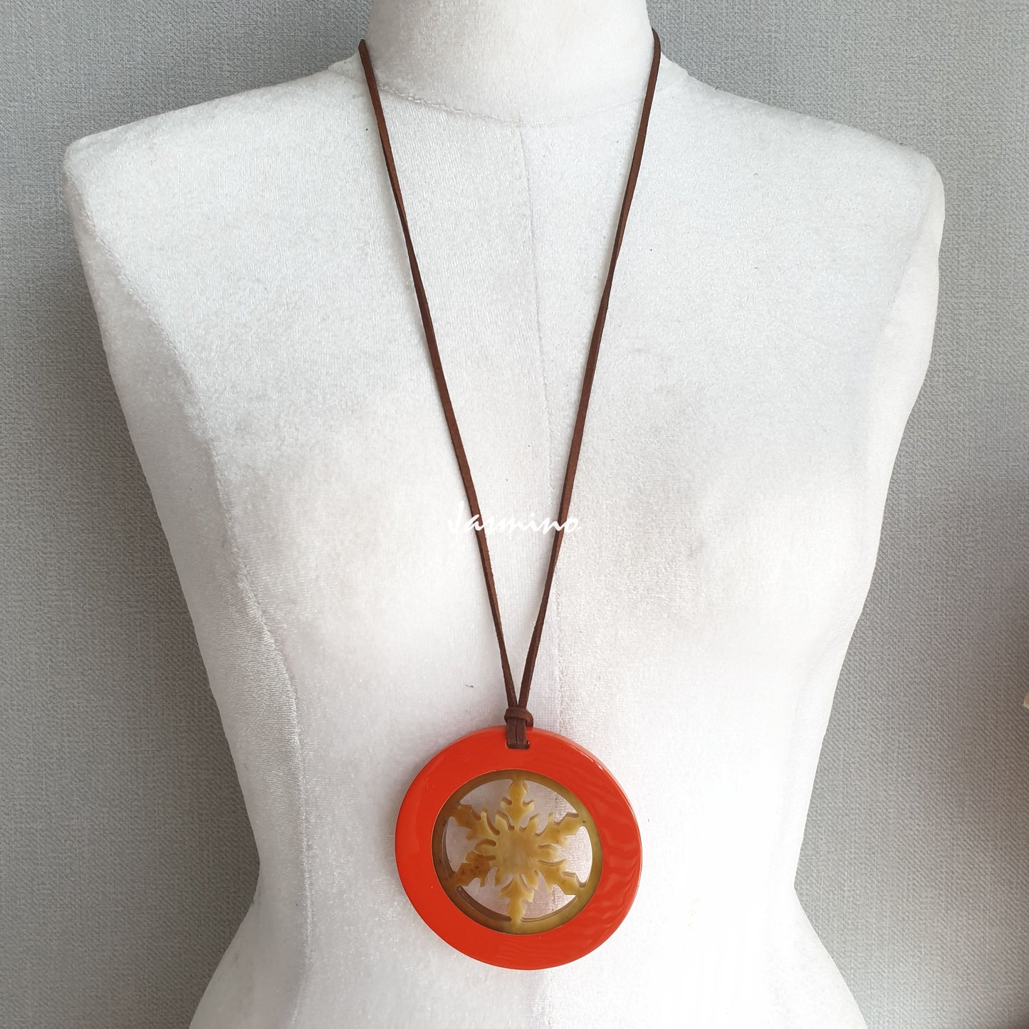 circular pendant is designed with orange peel outline, inside with snowflake pattern made of unique natural buffalo horn on a light background, impressive Christmas gift for her 