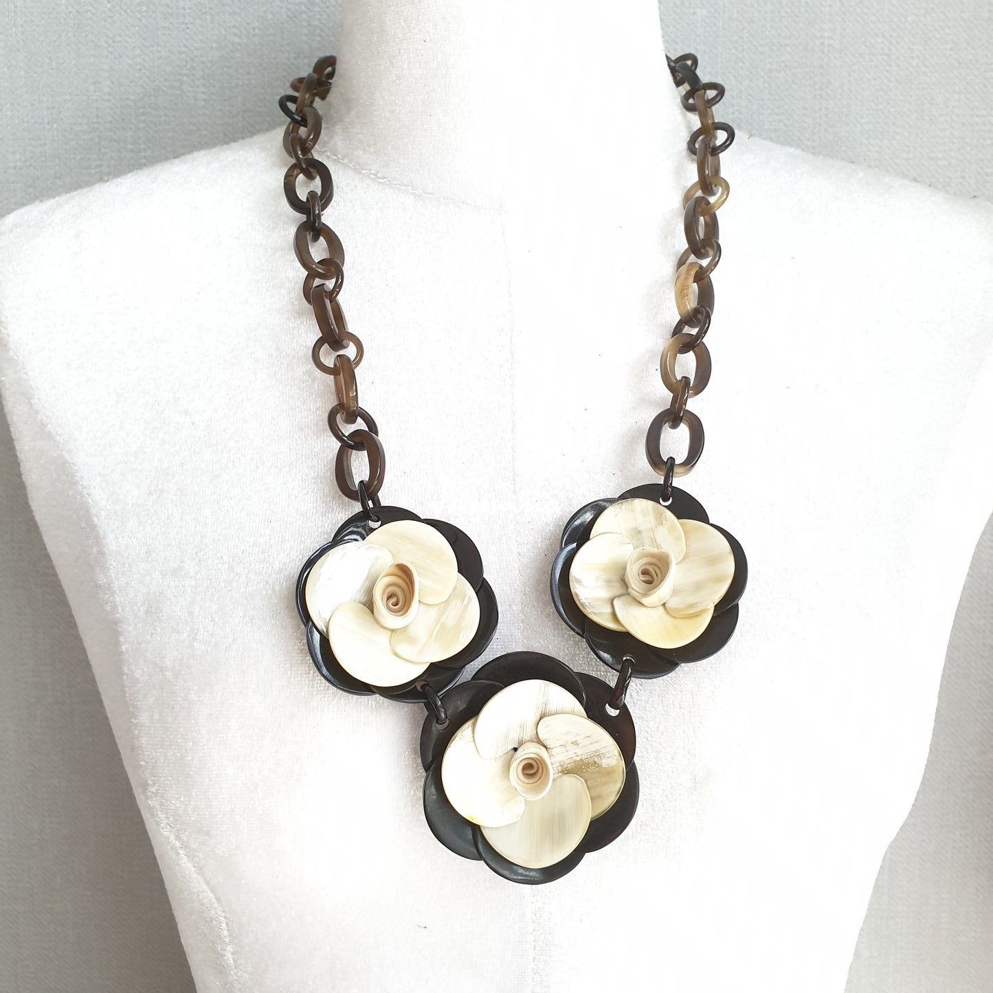 natural buffalo horn necklace with three white flowers centered in natural light