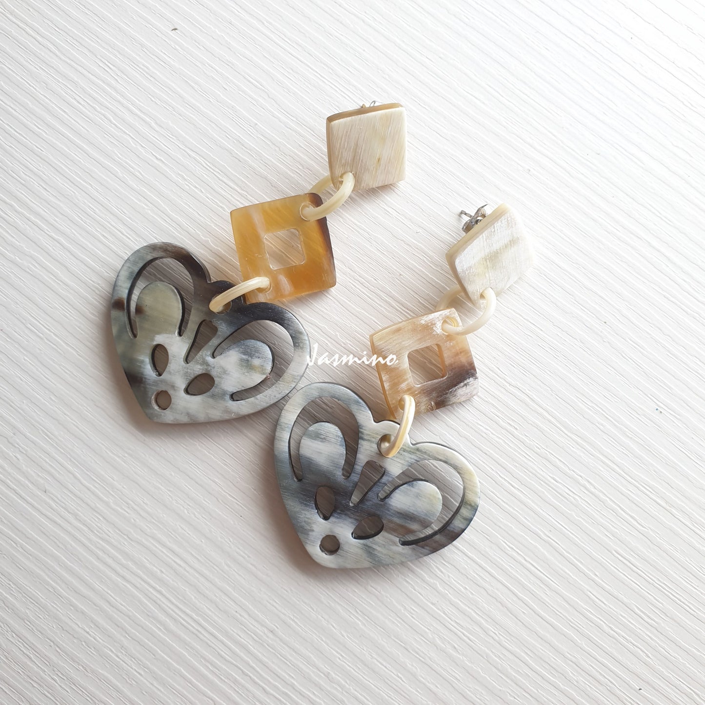 heart shaped horn earrings on the light background, unique gift for your friend