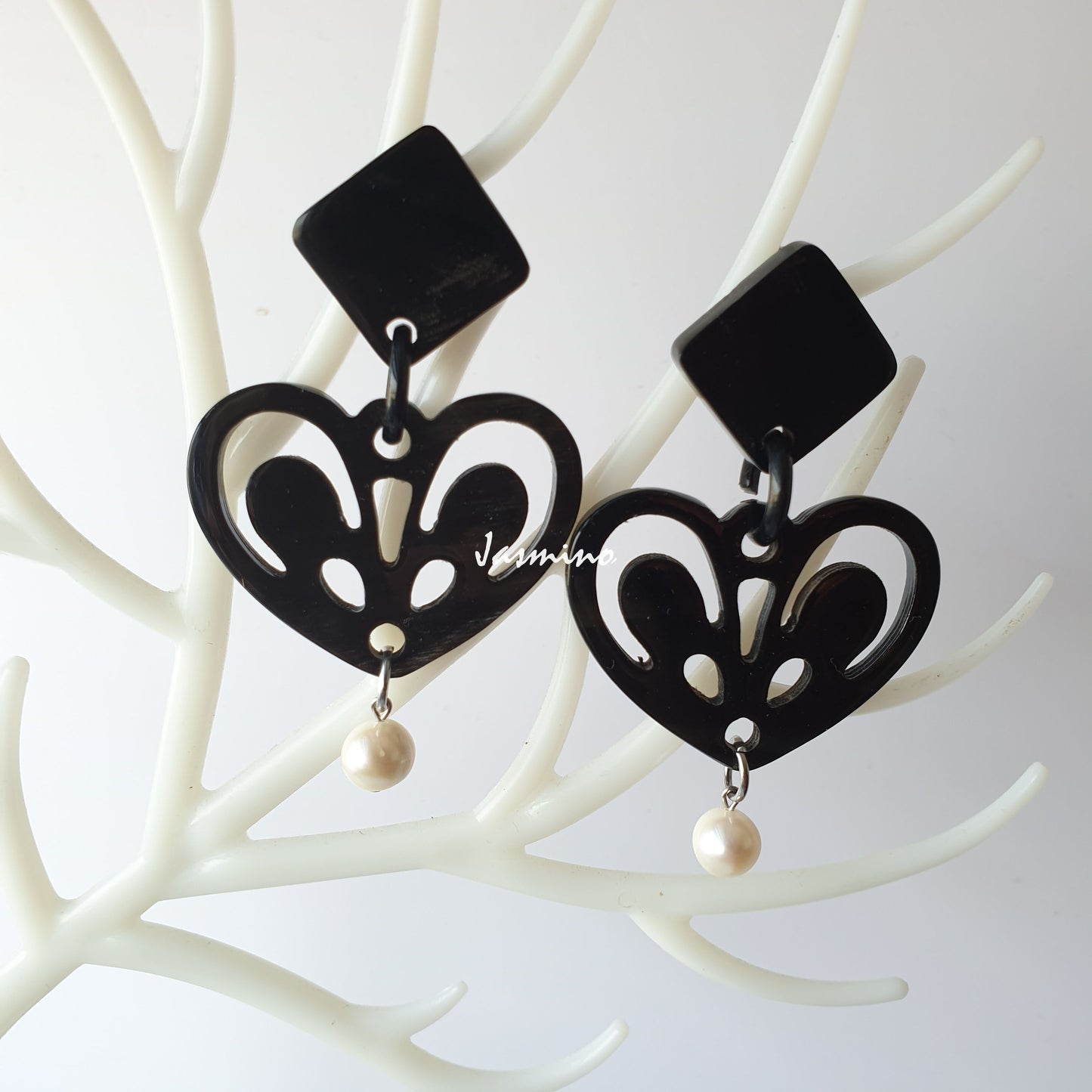 Princess drop earrings feature a black heart and white pearl on white faux branches