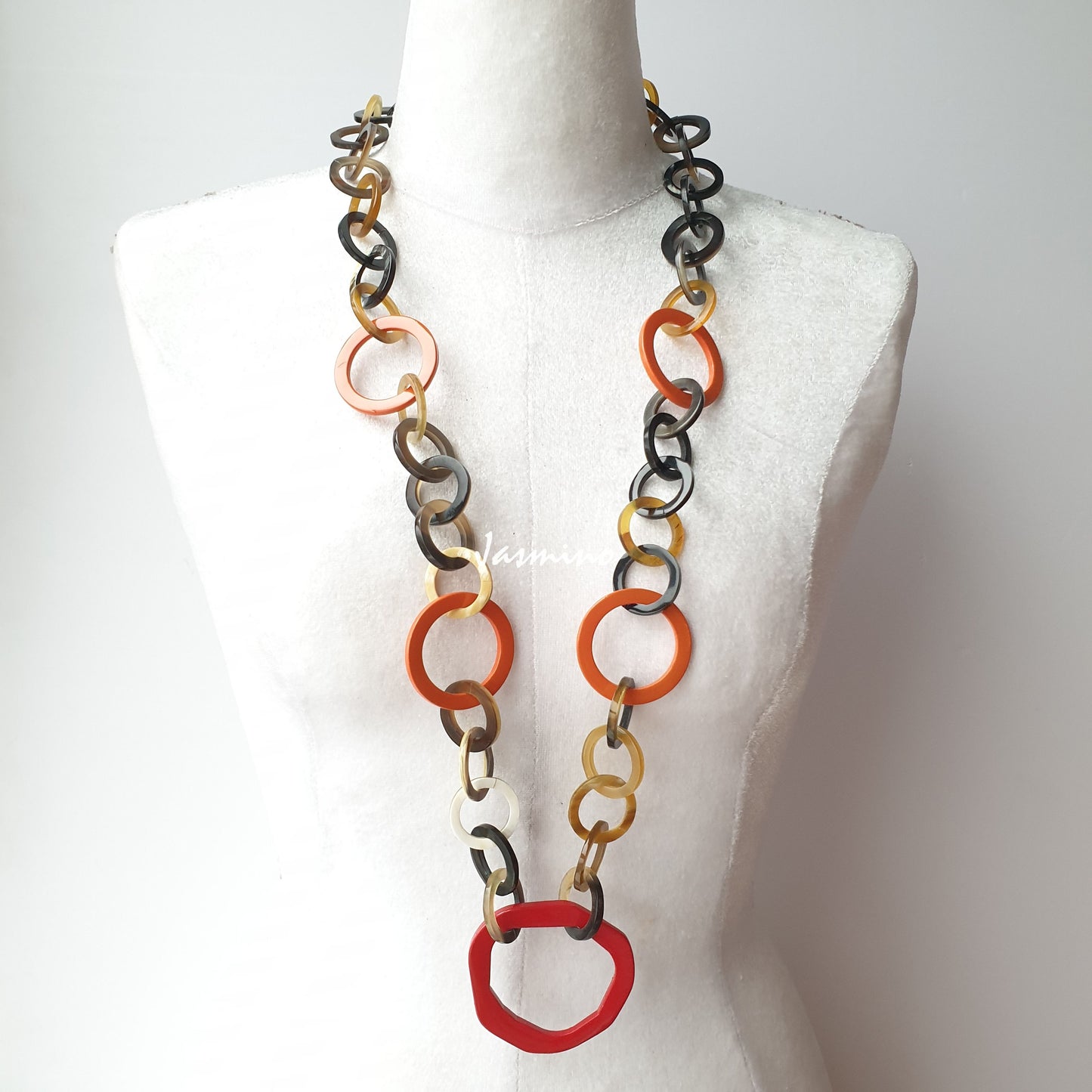 The necklace has some large orange peel links on the light background, a unique gift for her