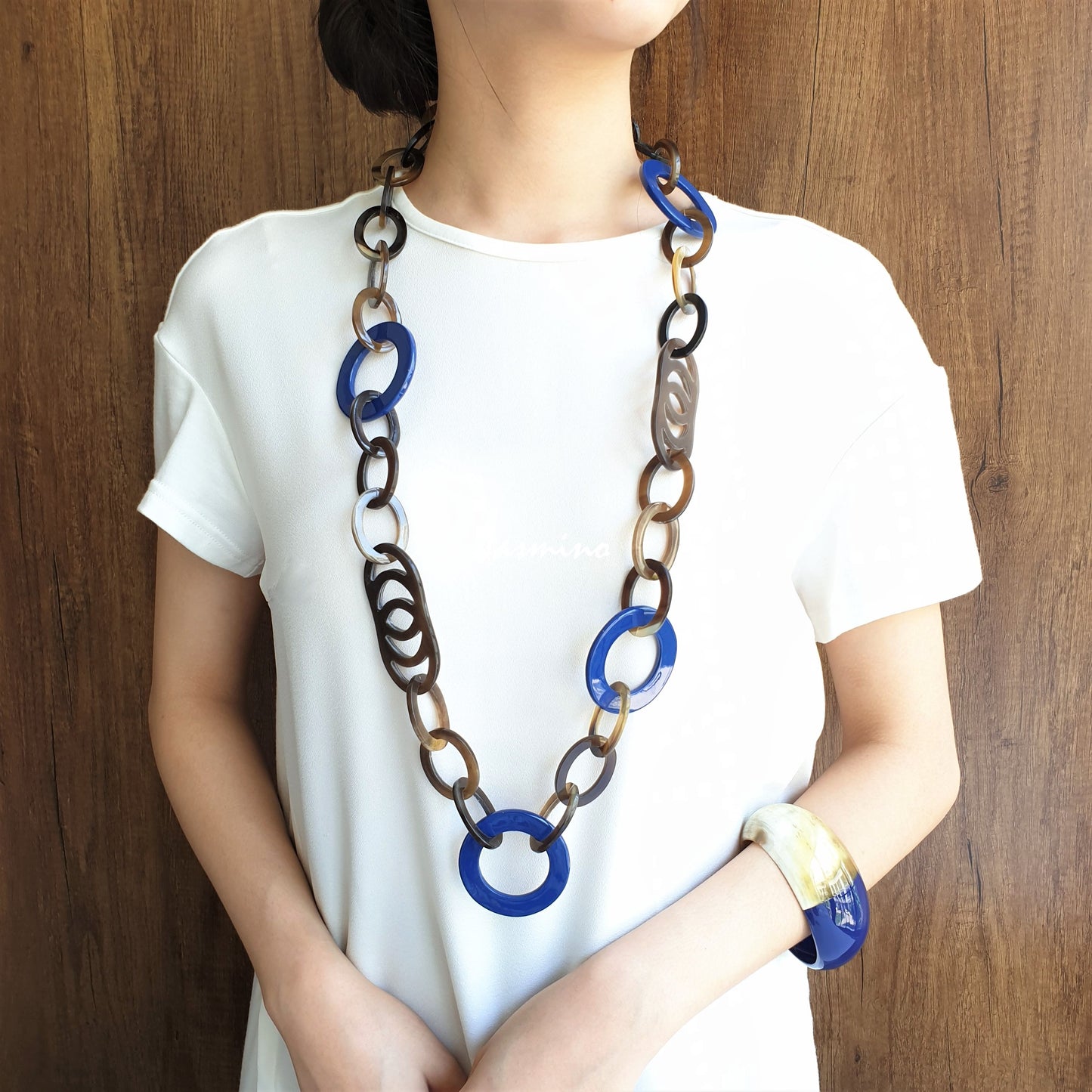 A model is wearing Jasmino unique handmade Bohemian chain link necklace featured blue and brown in natural buffalo horn