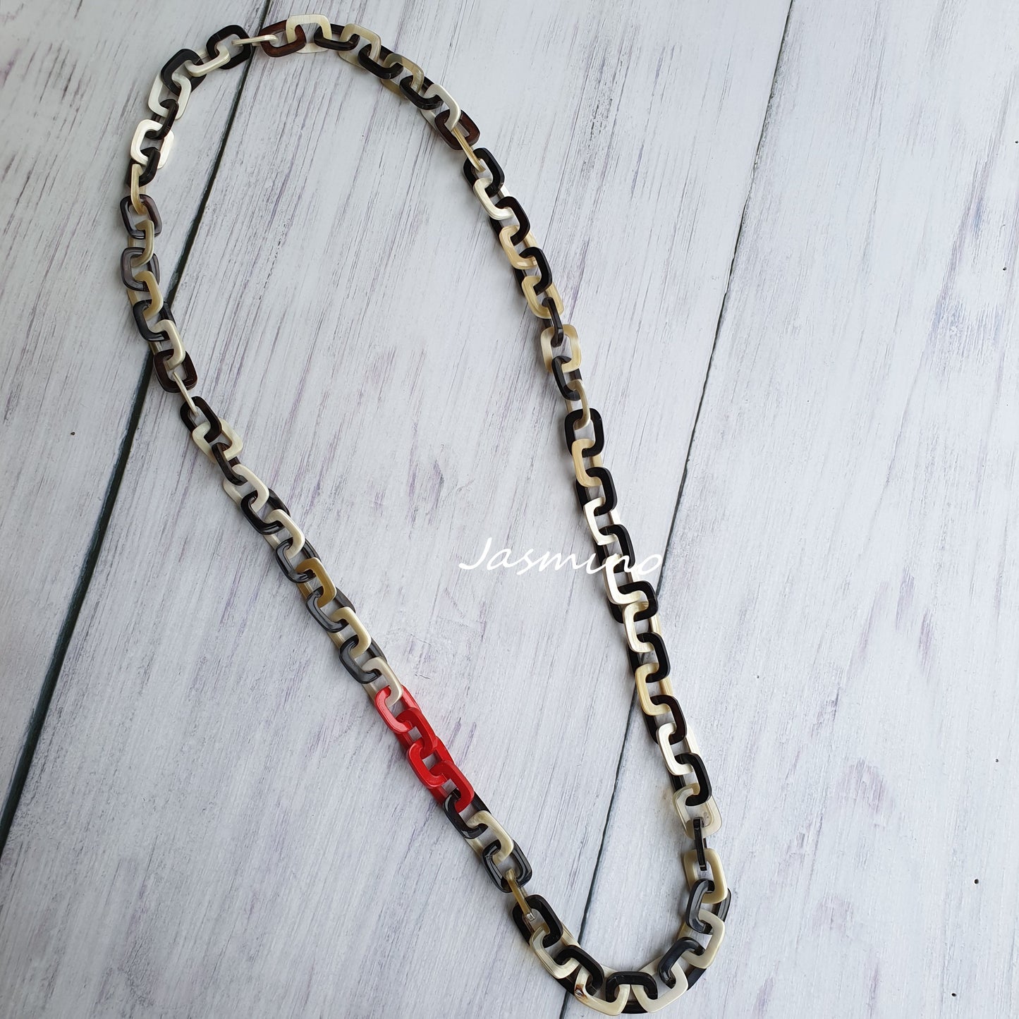 The necklace is designed with some red lacquer links in natural light, an impressive gift for her