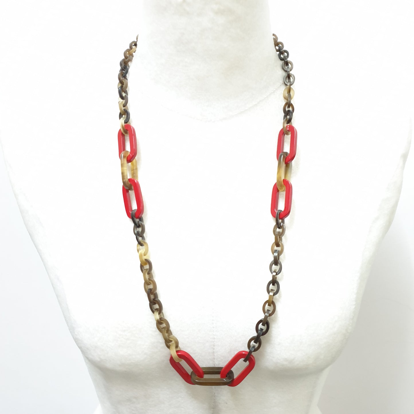 The necklace has some large red lacquered elliptical pieces in natural light, an impressive gift for her