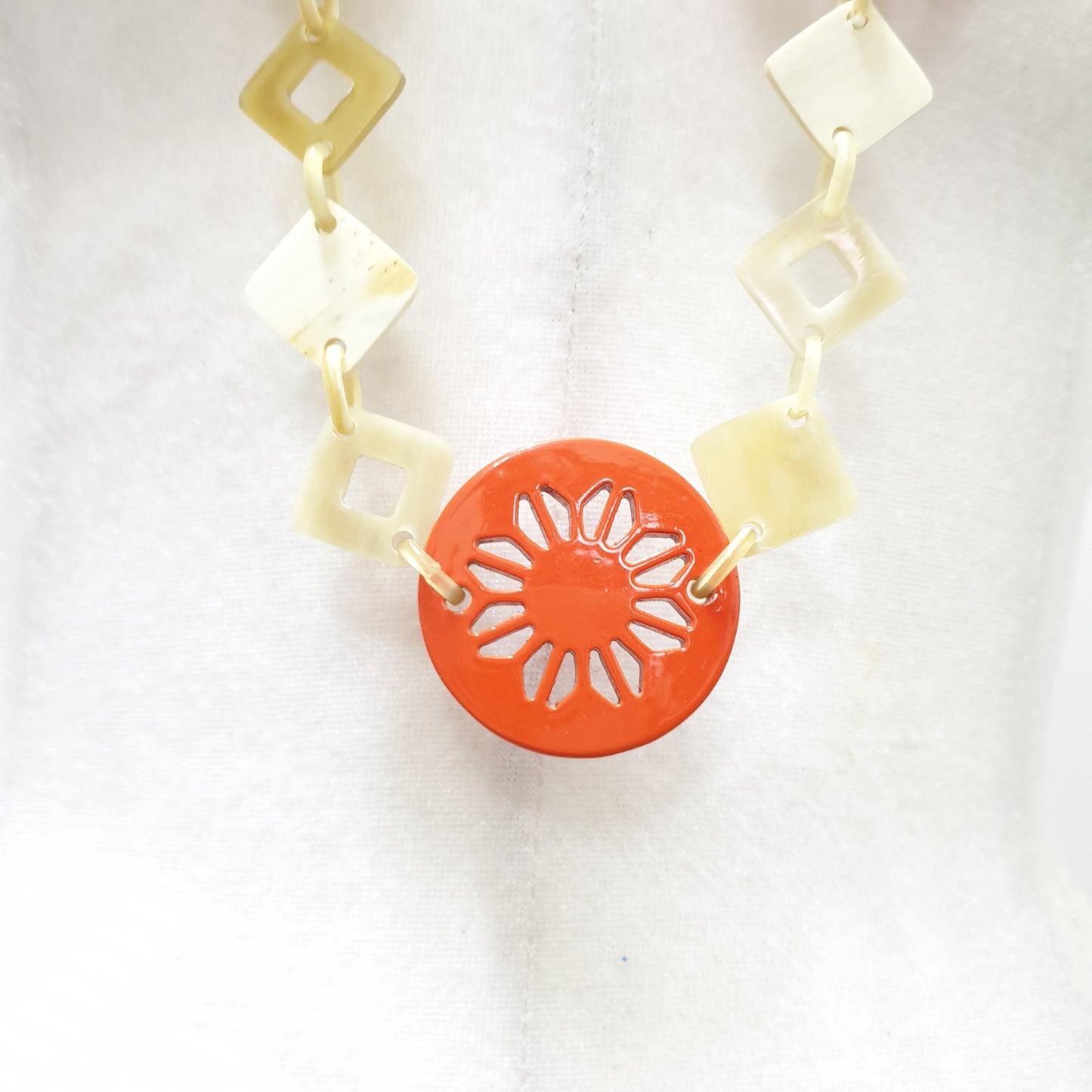 This necklace has some large orange pieces with different patterns on the light background, unique gift for your friend