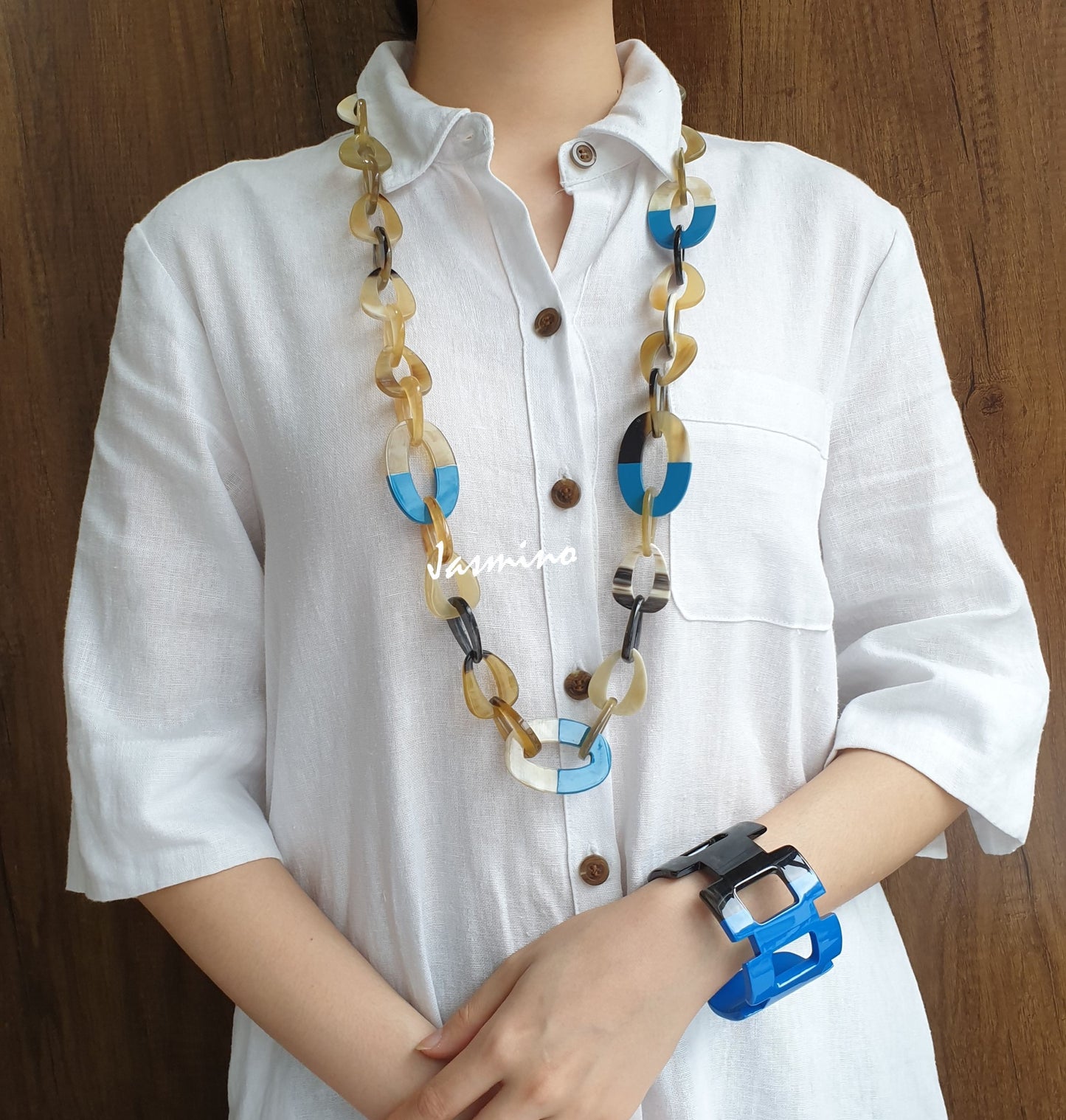 A model is wearing unique handmade necklace featured some large pieces with half natural horn and half blue lacquer, unique gift for her