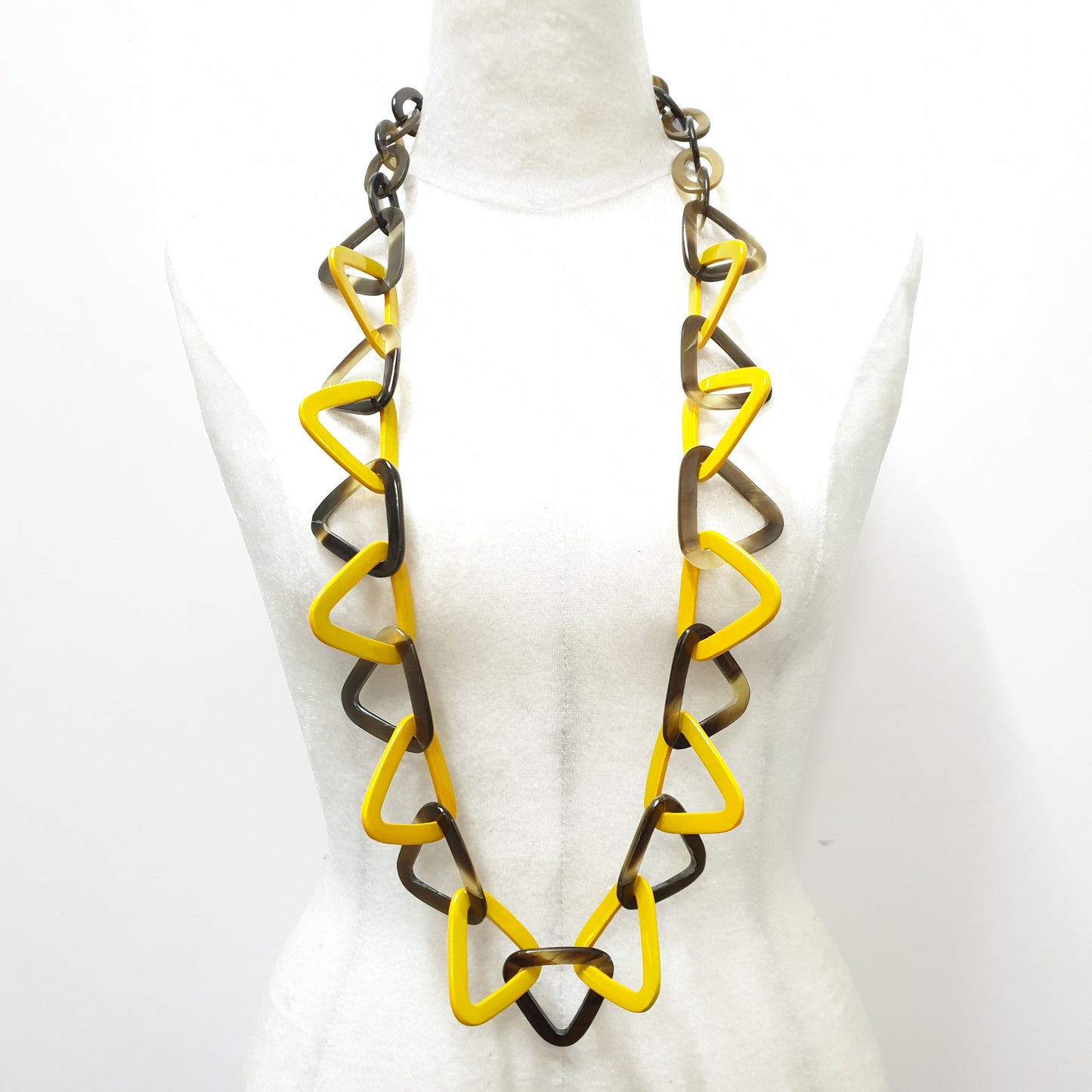 This necklace has several yellow lacquered triangular pieces on a light background, a unique gift for your friend