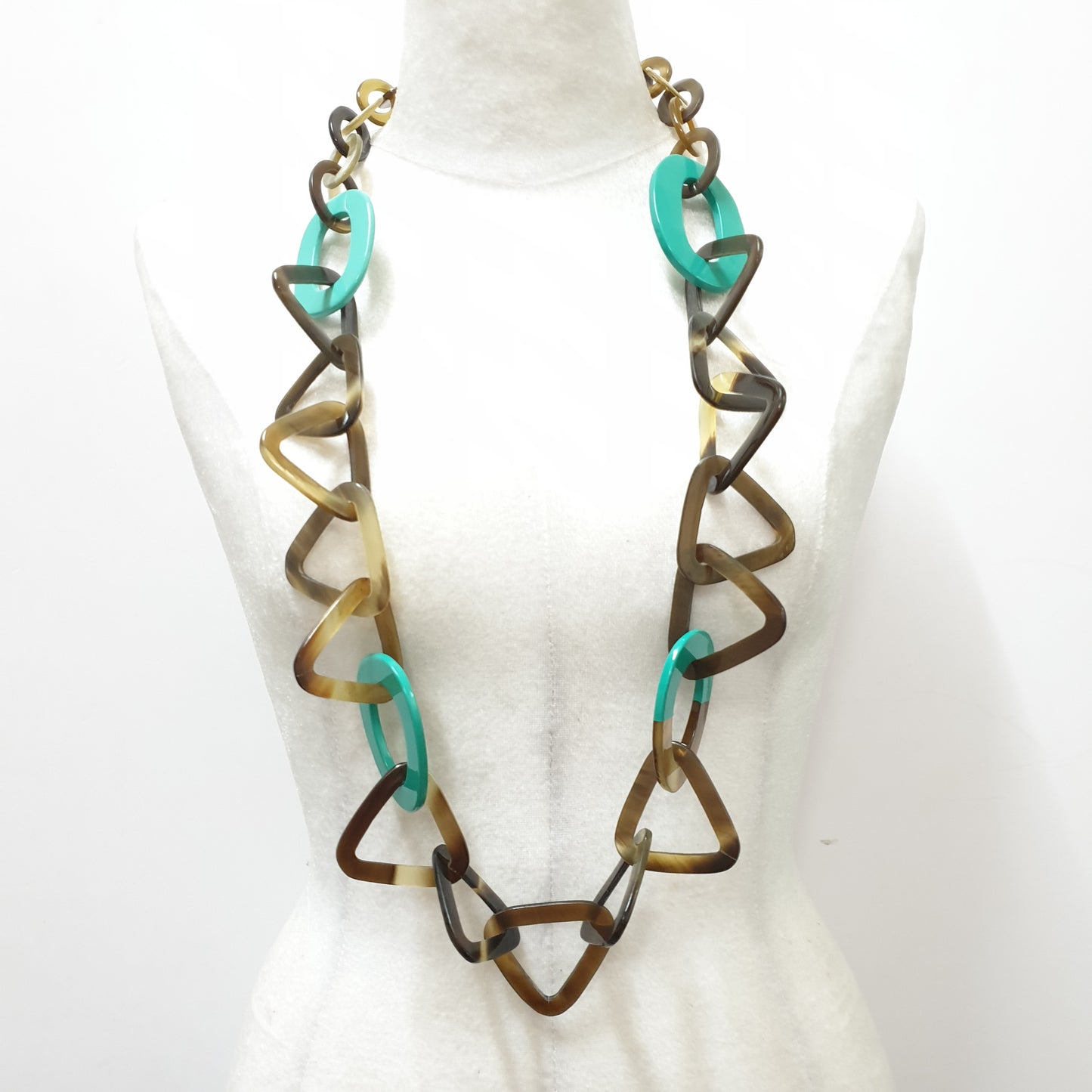 This necklace has several turquoise lacquered elliptical pieces on a light background, a unique gift for your friend