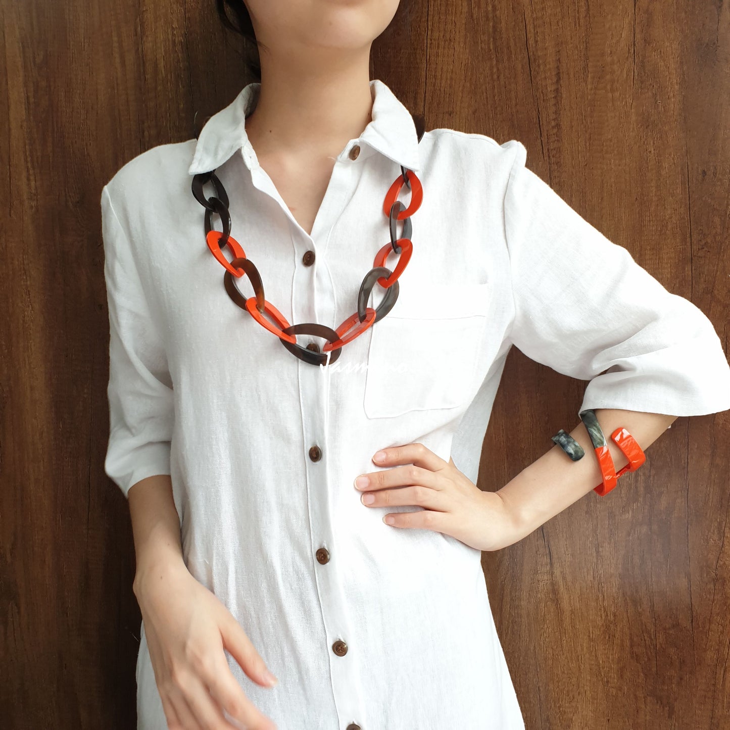 A model is wearing a set of Jasmino unique handmade Vintage chain link necklace cuff bracelet featured brown and orange in natural buffalo horn for women's gifts