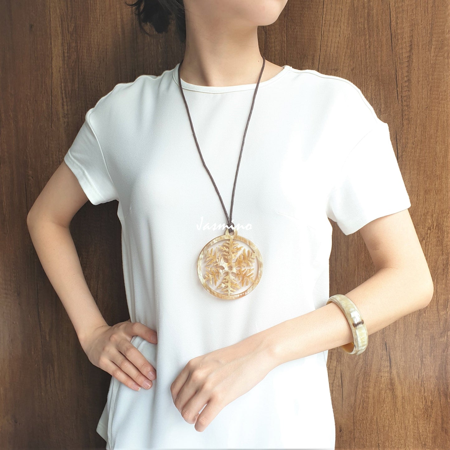 A model is wearing Jasmino unique handmade snowflake circle pendant features a bright colour that is made of natural buffalo horn for Christmas gifts