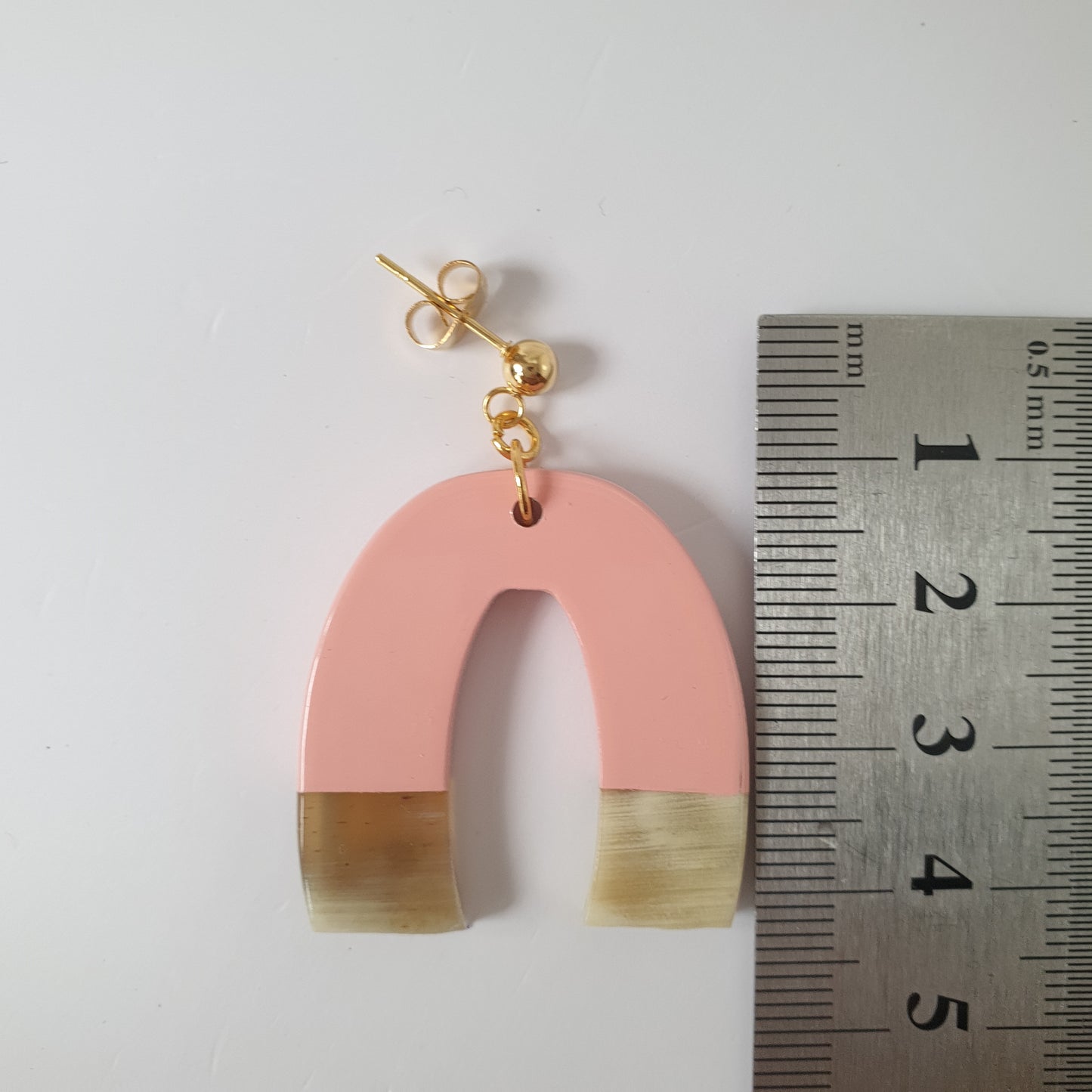 Bestselling pink U-shaped drop earring are handmade with natural buffalo horn material on  a white background