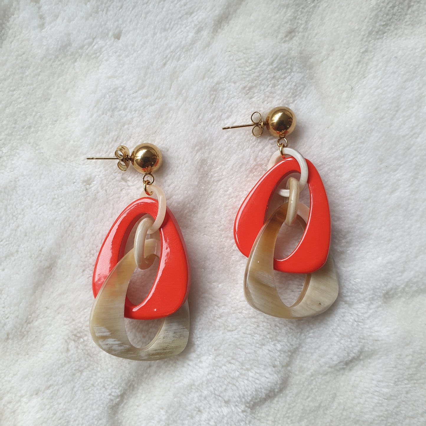 handmade double triangle earrings feature white and orange red in natural buffalo horn for Spring 2023