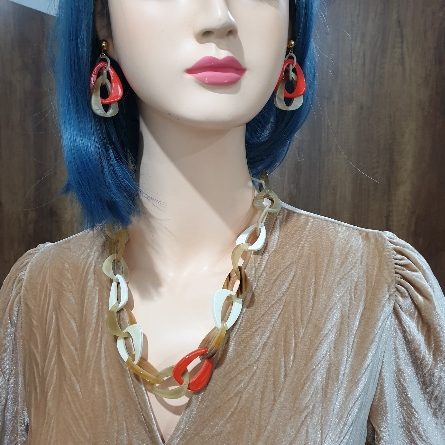 handmade double triangle earrings feature white and orange red in natural buffalo horn for Spring 2023 on a mannequin