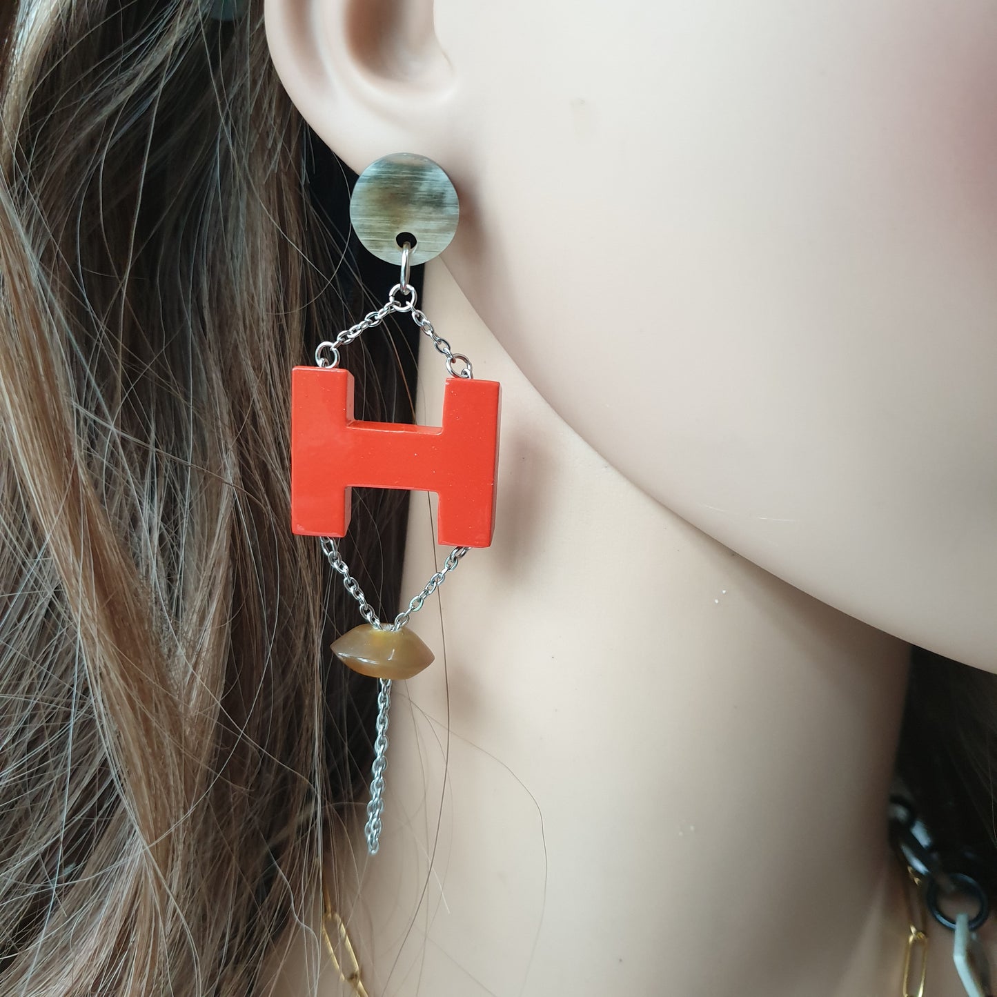 Handmade H-shaped earrings feature orange red in natural buffalo horn for Spring 2023