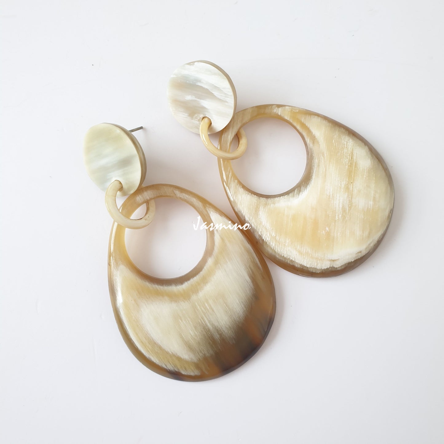 Handmade teardrop earrings feature ombre color with natural buffalo horn in the natural light