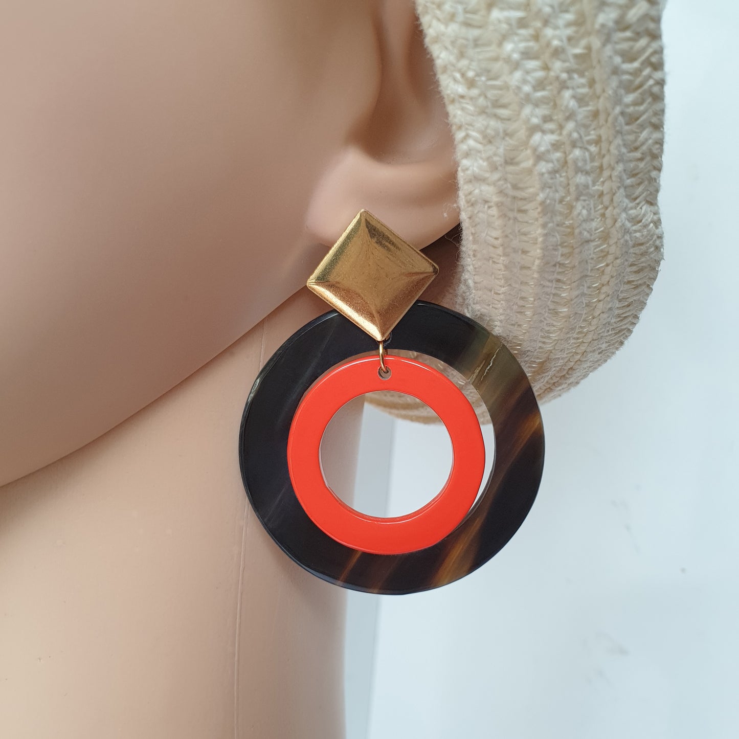 Double circle drop earrings for women are designed by black and red color with natural buffalo horn material that worn by a mannequin in the natural light